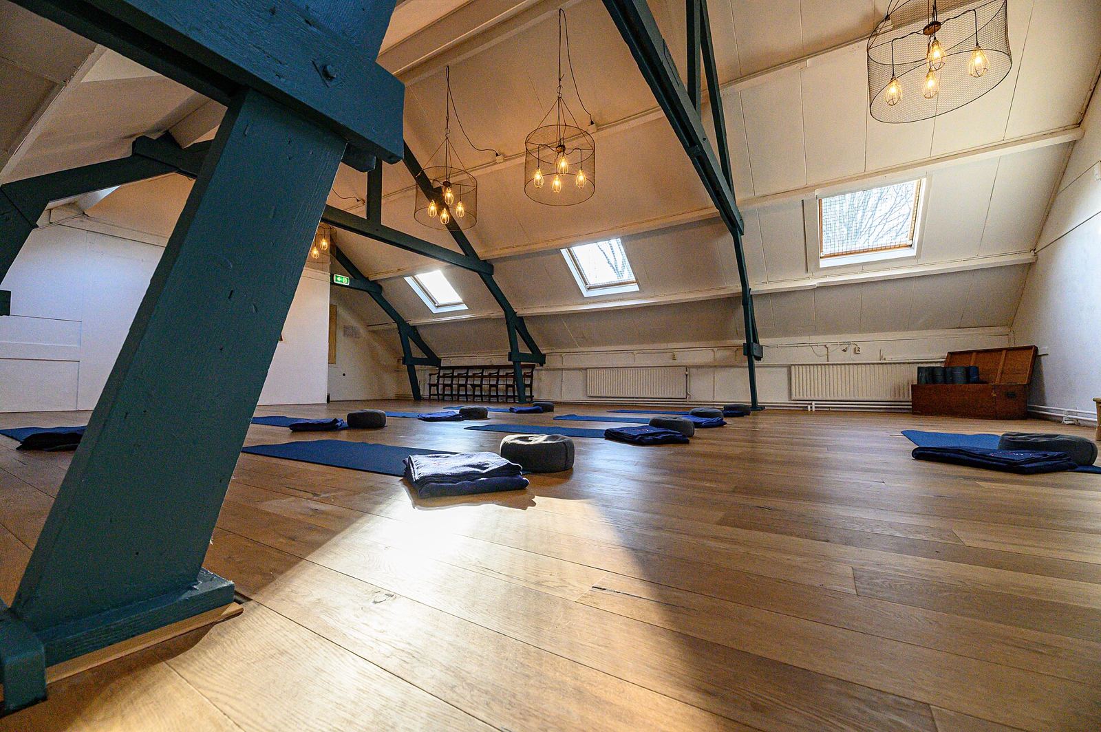 A beamed attic studio with mats on a wooden floor