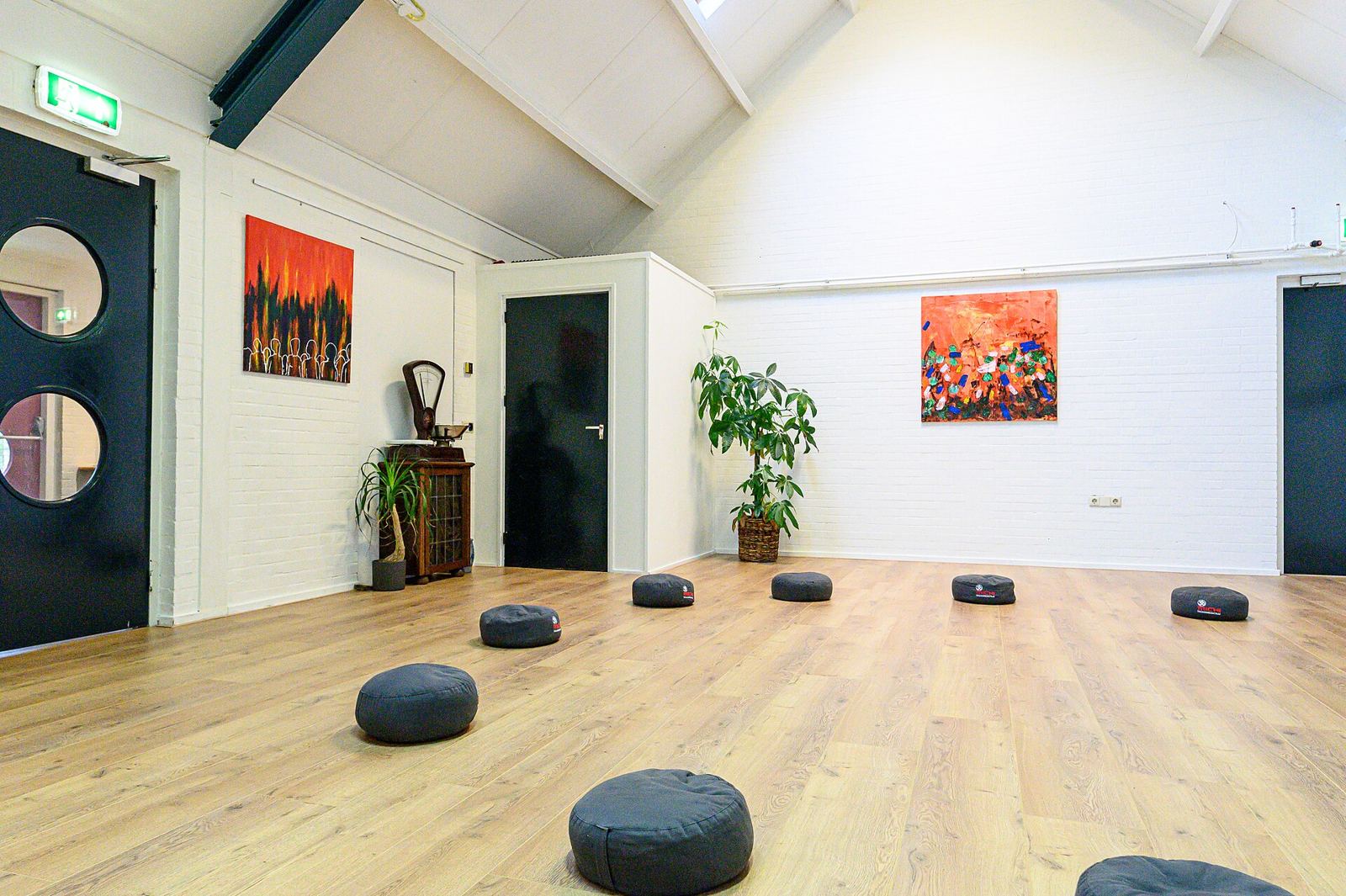 Cushions spaced across a wooden floor in a quiet studio